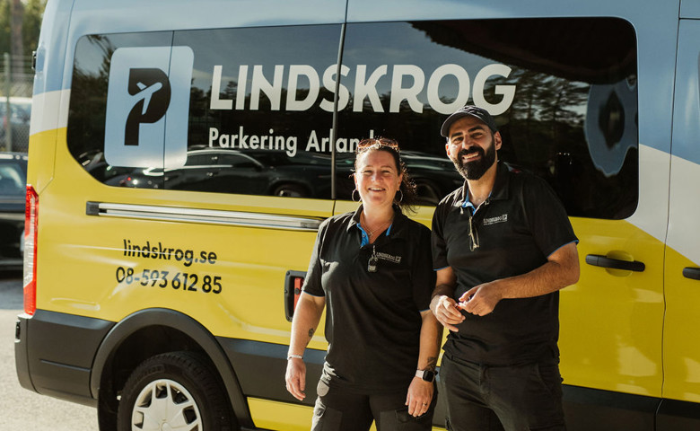 Trevlig personal framför en transferbuss märkt ”Lindskrog Parkering Arlanda”.
